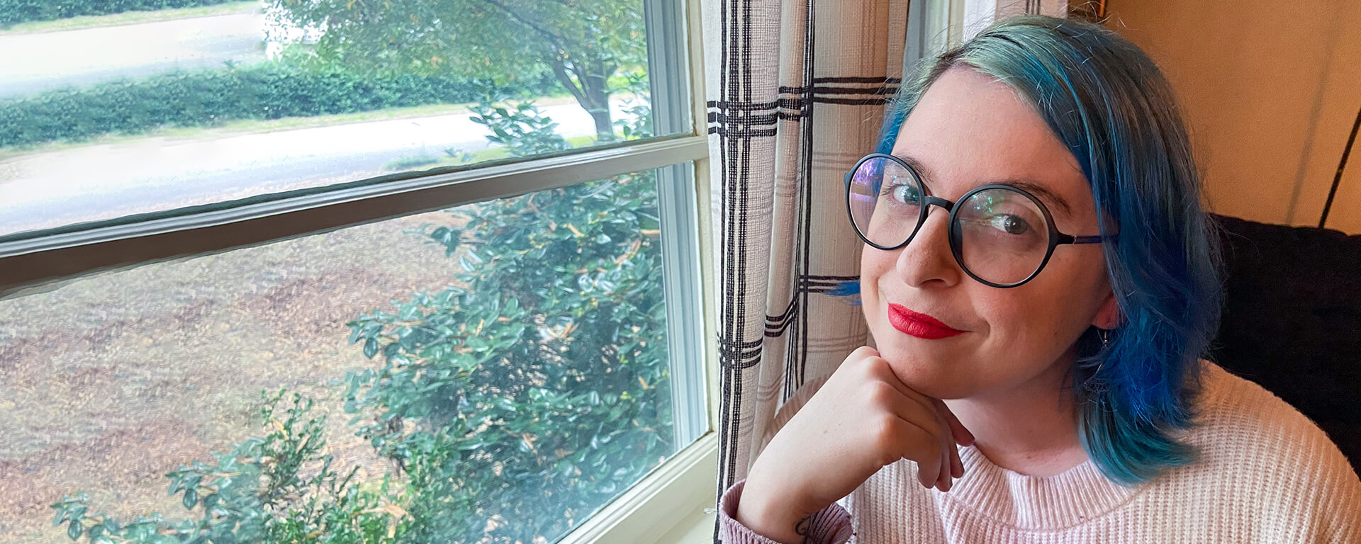 Capital One associate working remotely poses by her window